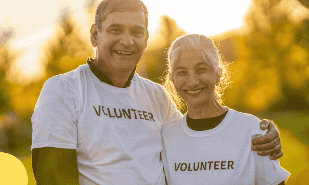 A happy retired couple smiling while volunteering together at a community event