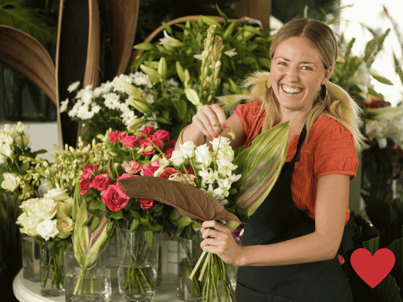 Woman arranging a bouquet of fresh flowers in a vase