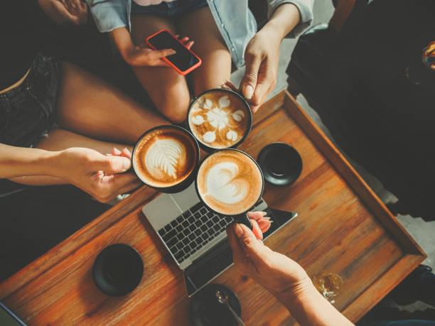 Group of people working and drinking hot coffee with latte art in the cafe.