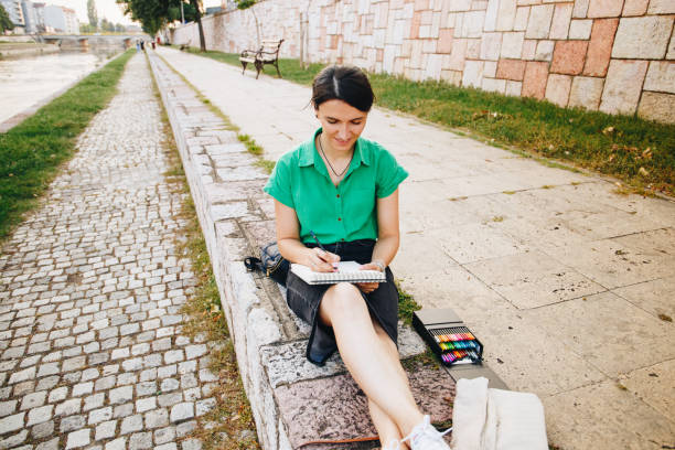 Young woman drawing outdoors stock photo