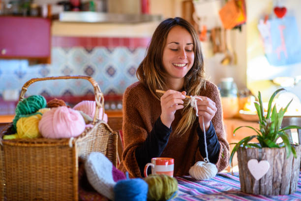 A cozy scene with yarn, knitting needles, and a partially finished scarf resting on a soft blanket — showcasing knitting and crocheting as calming hobbies for introverts who enjoy quiet, hands-on creativity.