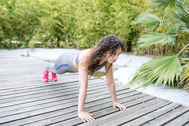 Woman doing push-ups to build upper body strength as part of workout routines for women over 40
