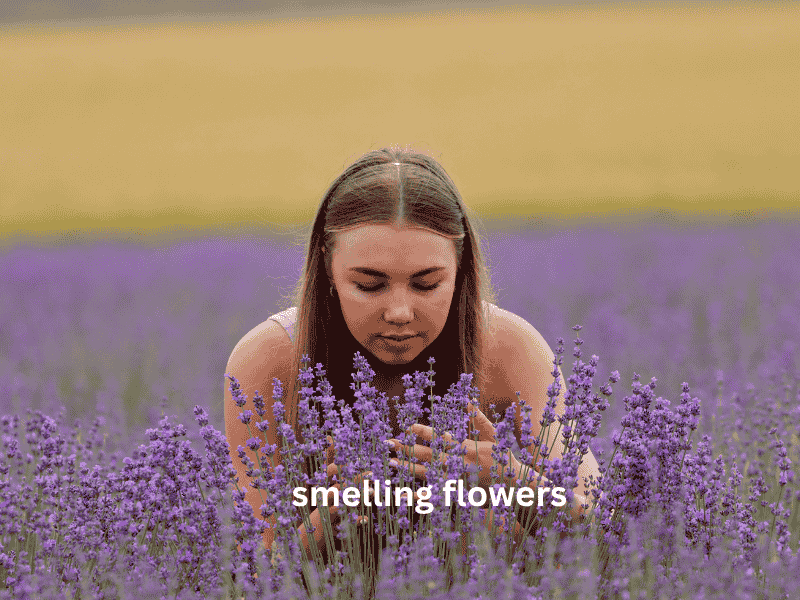A girl gently smelling fresh herbs and flowers, enjoying a calming and sensory-rich experience