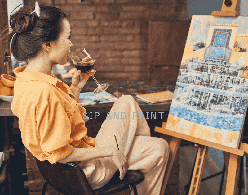 Women enjoying a sip and paint night with wine and canvases