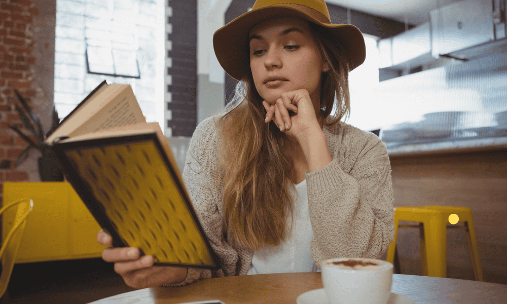 Young woman reading self improvement book for personal growth.