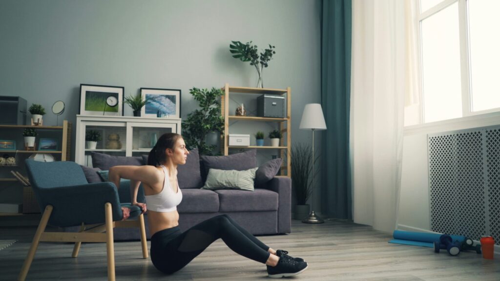 Woman doing a home workout in her living room, staying active indoors to boost energy and fitness on a rainy day.