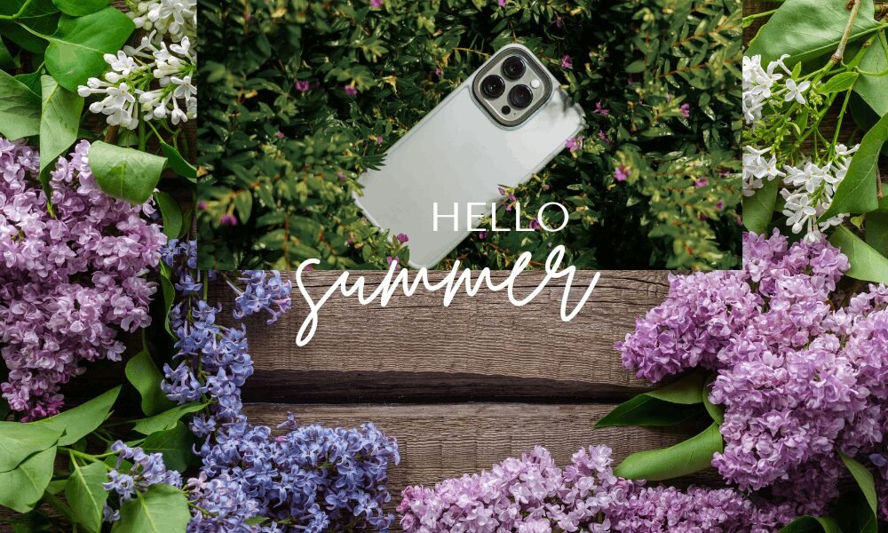 A bright summer-themed wallpaper featuring an iPhone placed among lush green leaves and small pink flowers, framed by blooming lilac blossoms in soft purple and white tones on a rustic wooden background, with the text Hello Summer in elegant script.